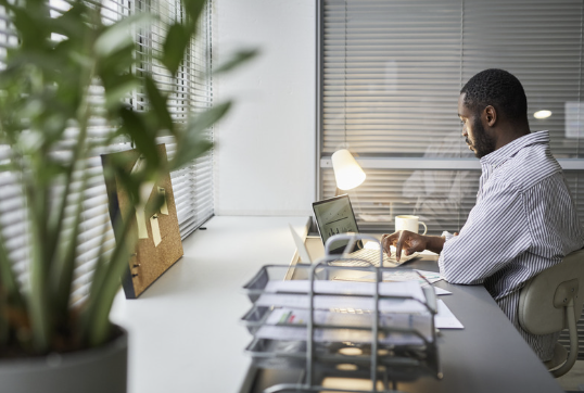 Professional at a desk after hours, illustrating perfectionism and burnout.